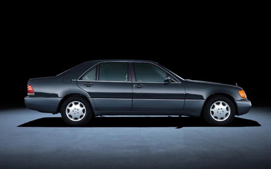 The side view of a black V12-powered 1992 Mercedes-Benz W140 S-Class sedan