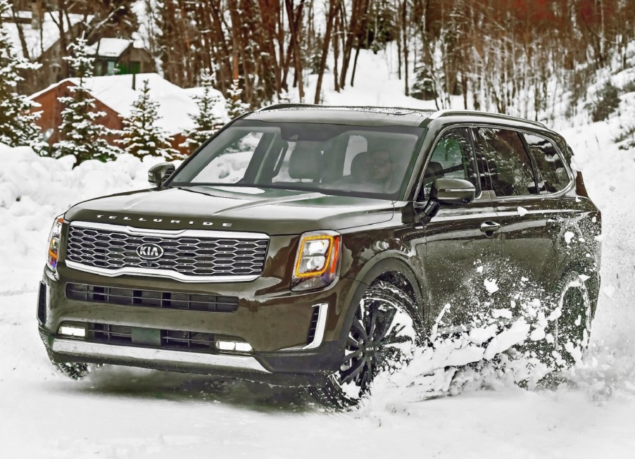 A green 2020 Kia Telluride drives through the snow