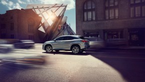 2020 Lexus RX 350 driving through the city near an apartment building