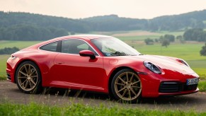 A red 2020 Porsche 911 Carrera amongst rolling green hills