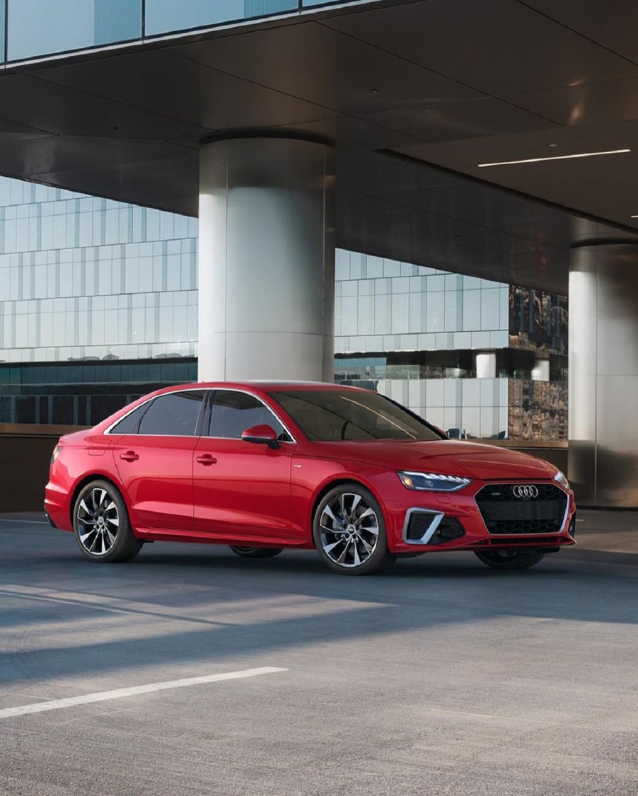 A red 2021 Audi A4 in front of a modern building