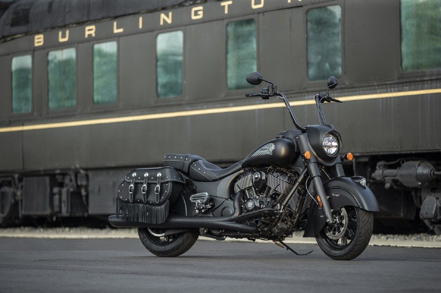 A black 2021 Indian Vintage Dark Horse with optional tall handlebars in front of a train