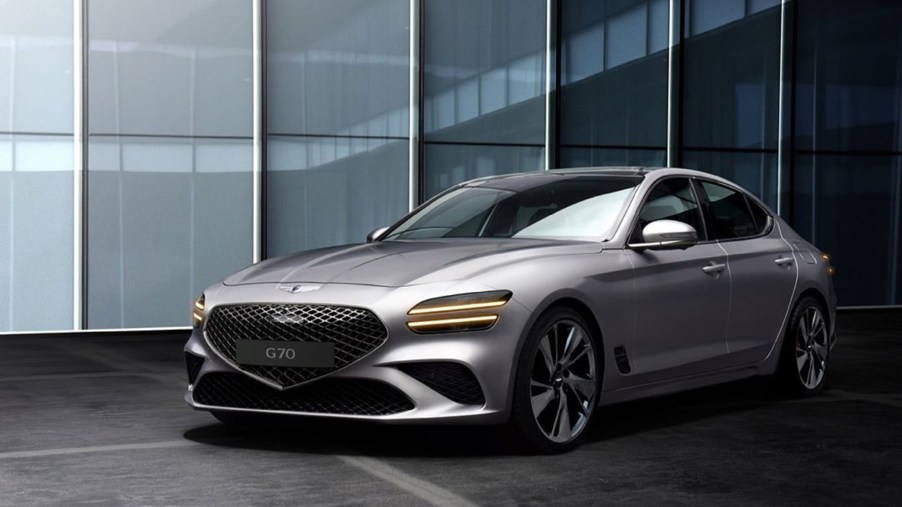 A silver 2022 Genesis G70 in front of some glass windows