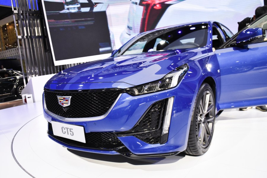 A blue Cadillac CT5 on display at an auto show