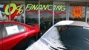 A car dealership advertising financing deals on the window to entice those car shopping.