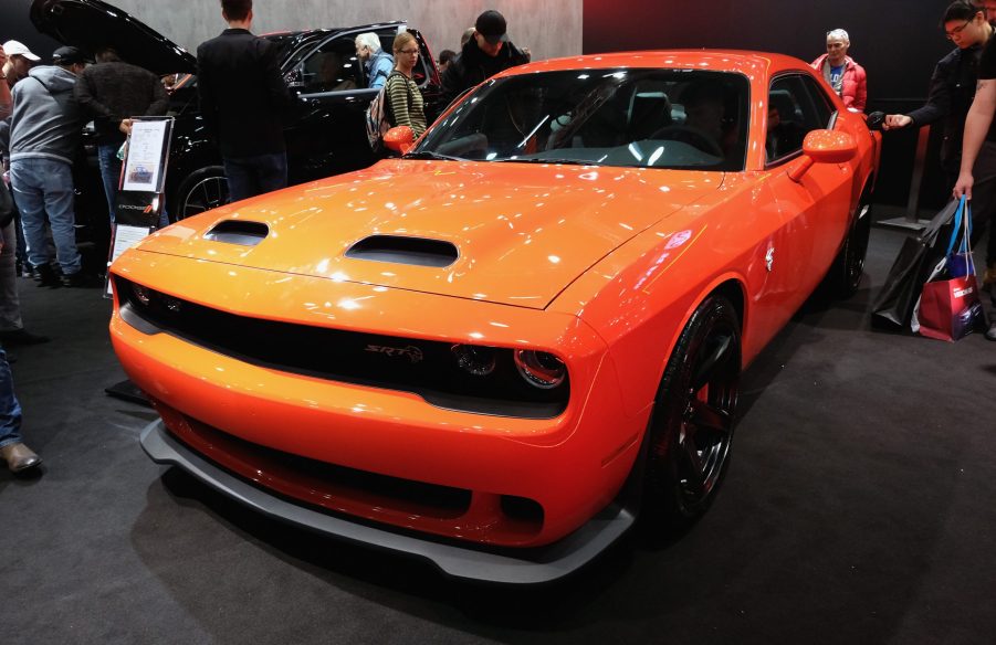 An orange Dodge Charger on display at an auto show