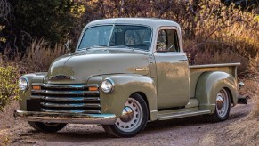 A green-and-vanilla Icon 4x4 Old School Edition Thriftmaster pickup in a sunlit forest