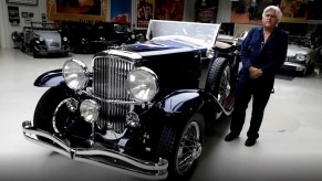 Jay Leno and his dark-blue 1930 Duesenberg LeBaron