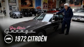 Jay Leno next to his brown 1972 Citroen SM