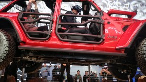 An attendee wears a virtual reality headset while riding in a show version of a 2020 Jeep Wrangler Unlimited 4xe plug-in hybrid electric vehicle