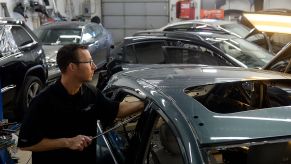 ENGLEWOOD, CO - JANUARY 22: Auto body shops in the Denver metro area are packed with cars. Cars with hail damage from last year and cars needing repair from the winter collision season have filled the garages. At Hampden Auto Body in Englewood, CO Eric Nelson a paintless dent specialist pops dents out of the roof of a car with with hail damage on Thursday, January 22, 2015. (Photo by Cyrus McCrimmon/The Denver Post via Getty Images )