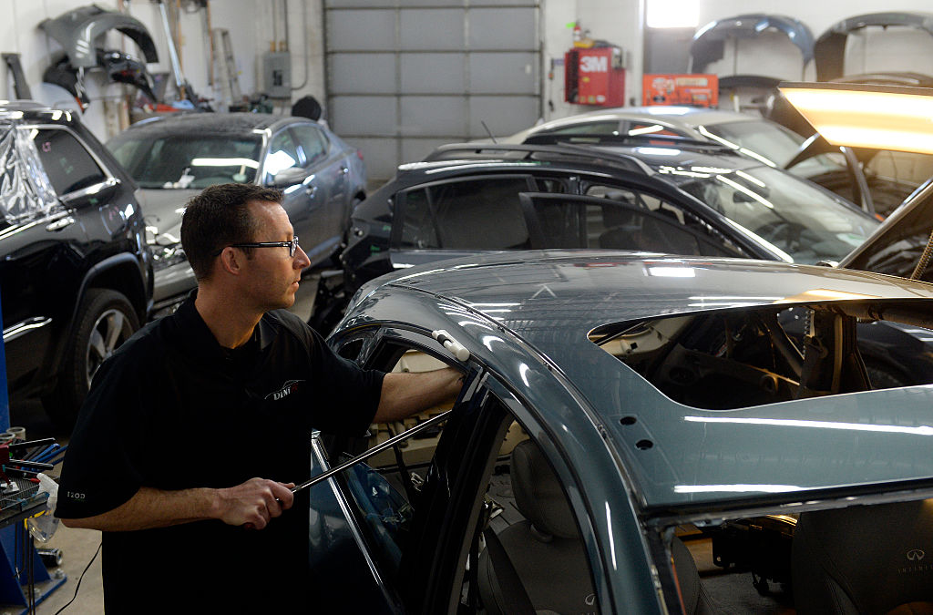 ENGLEWOOD, CO - JANUARY 22: Auto body shops in the Denver metro area are packed with cars. Cars with hail damage from last year and cars needing repair from the winter collision season have filled the garages. At Hampden Auto Body in Englewood, CO Eric Nelson a paintless dent specialist pops dents out of the roof of a car with with hail damage on Thursday, January 22, 2015. (Photo by Cyrus McCrimmon/The Denver Post via Getty Images )