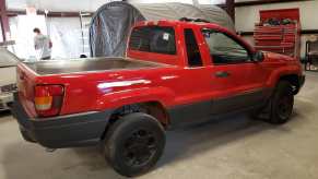 A red Jeep Grand Cherokee has a been cut into a pickup.