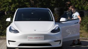 A man films himself looking at a Tesla Model Y