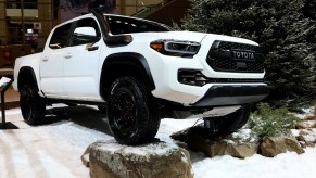 A white Toyota Tacoma displayed at an auto show.