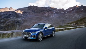 An electirc blue 2021 Audi Q5 Sportback driving on the countryside.