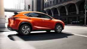 a cadmium orange lexus nx 300 f sport driving in the city