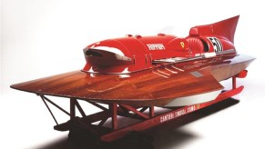 The red-and-mahogany 1952 Ferrari Arno XI hydroplane on its stand