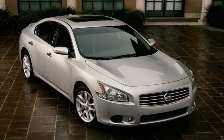 A light gray 2011 Maxima on a brick road. 