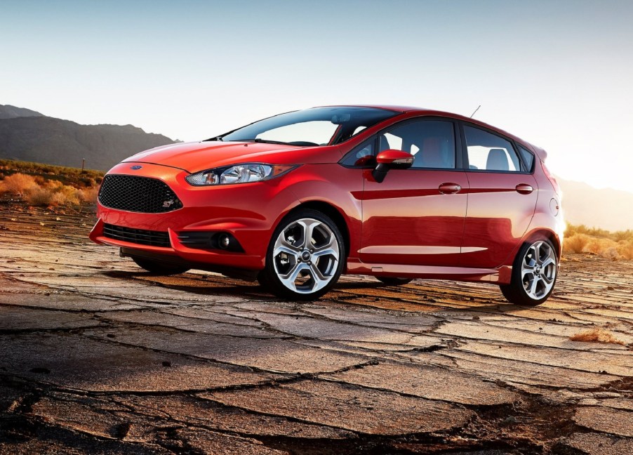 An orange 2014 Ford Fiesta ST parked on desert asphalt