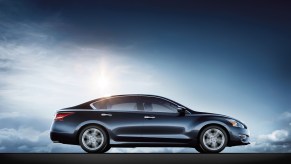 The 2017 Nissan Altima parked for display in front of a blue and black background