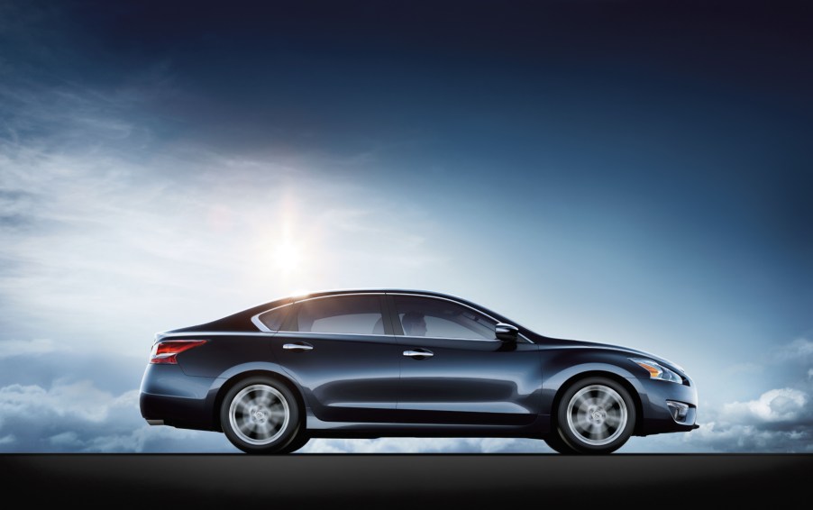 The 2017 Nissan Altima parked for display in front of a blue and black background