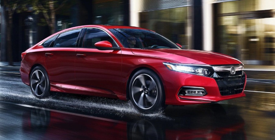 A red 2020 Honda Accord Sport 2.0T drives through a rain-soaked city