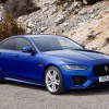 A blue 2020 Jaguar XE in front of a rocky hill