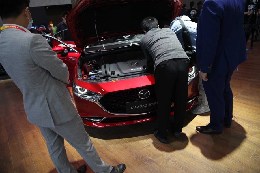 People checking out a Mazda3 at an auto show