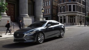 The 2020 Mazda6 driving down a city street with buildings in the background