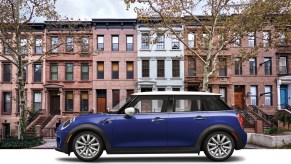 A blue 2020 Mini Cooper Oxford Edition on display in front of a building