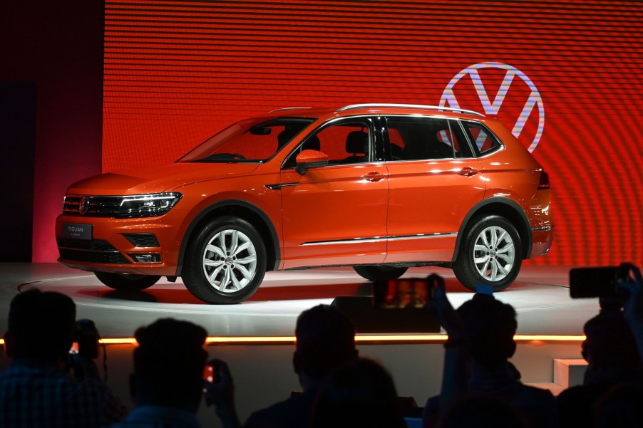 The 2020 Volkswagen Tiguan on display at an auto show with the VW logo in the background