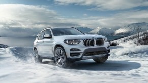 A white 2021 BMW X3 xDrive30e on a snowy mountain