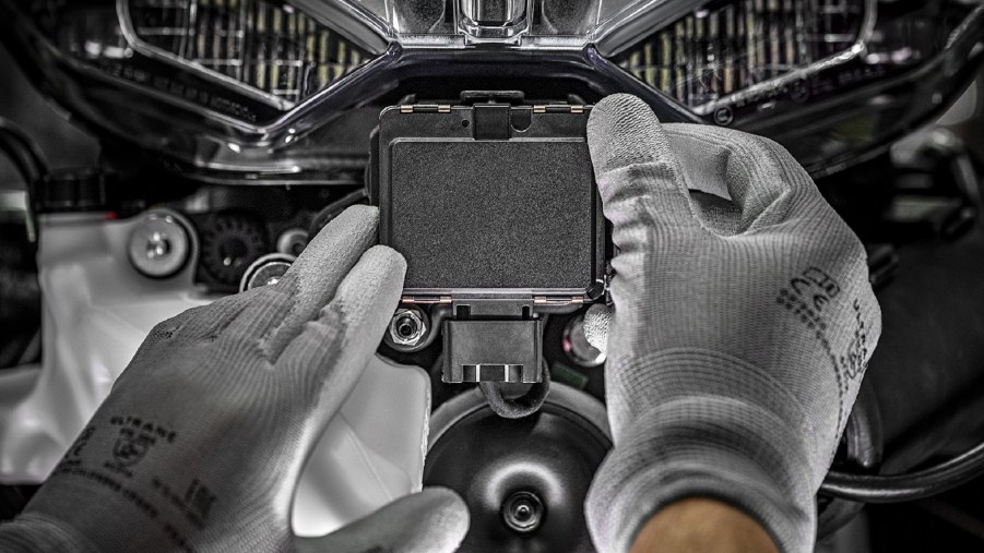 Gray-gloved hands install a radar unit on a 2021 Ducati Multistrada V4