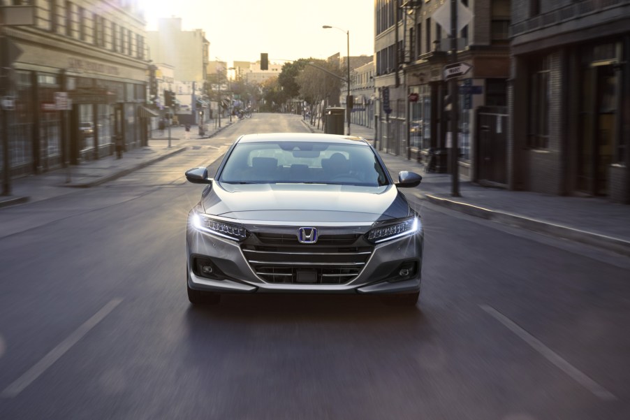 A 2021 Honda Accord Hybrid driving down a city street