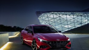 A red 2021 Hyundai Elantra N Line on display in front of a building