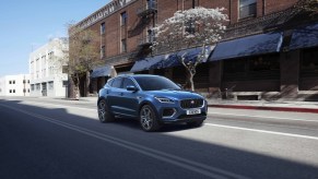 A blue 2021 Jaguar E-Pace driving down a city street