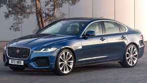 A blue 2021 Jaguar XF in front of a white building