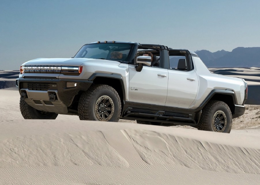 A white 2022 GMC Hummer EV climbs a dune