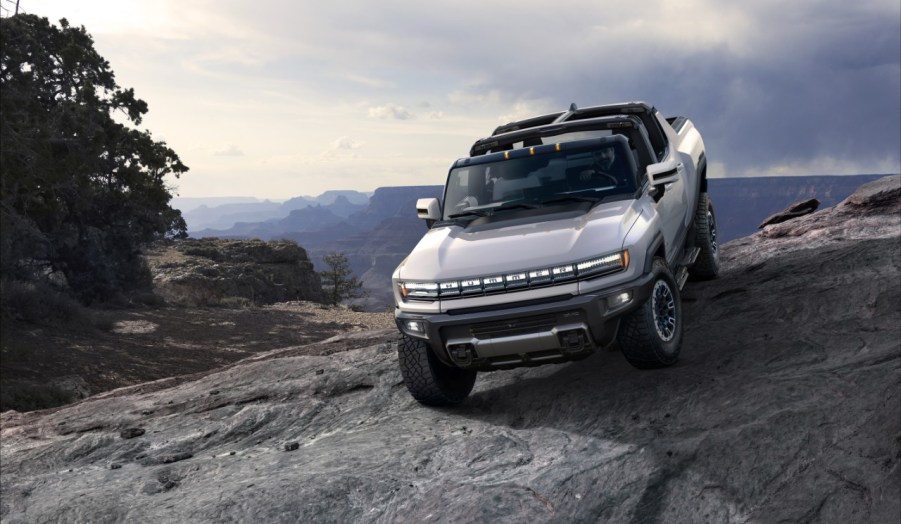 A silver 2022 GMC Hummer EV traversing rocky terrain