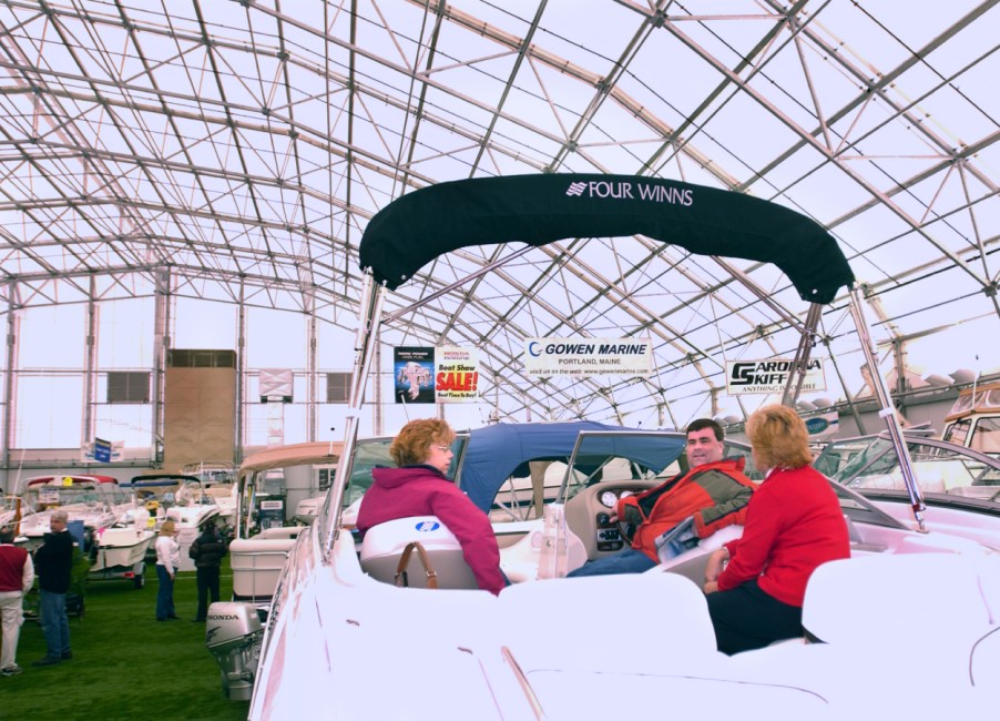 A family sitting in a boat at a display