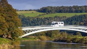 A camper van travels from the England to Wales over Bigsweir Bridge which spans the River Wye between Wales and England