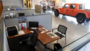 Car shopping: Empty desk at car dealership with Jeep in background