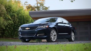 A Chevy Impala parked in the driveway in front of a house