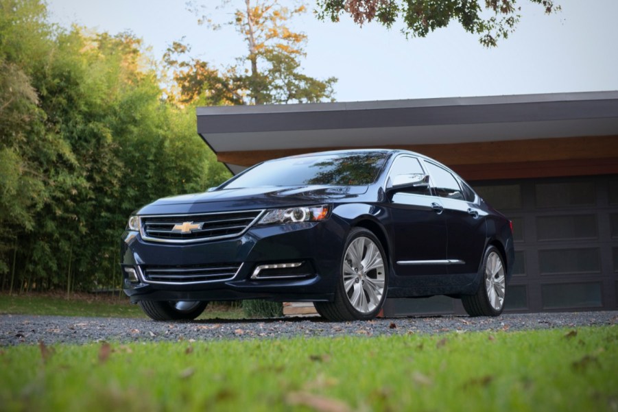 A Chevy Impala parked in the driveway in front of a house