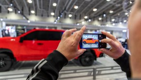 A man photographs a model 2019 Chevy Silverado pick up truck