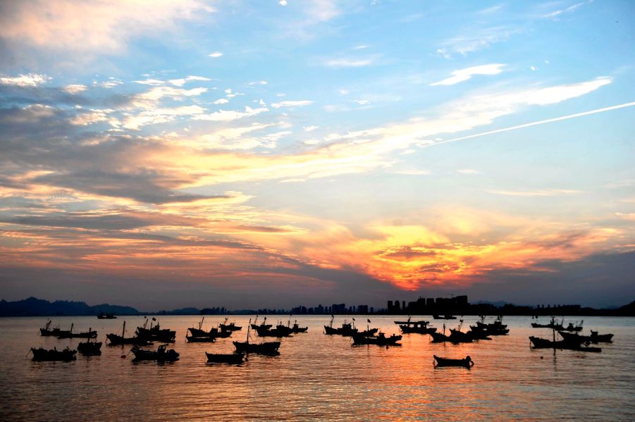 Returning fishing boats moor under the sunset in Qingdao, Shandong Province, China