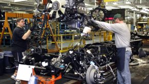 Workers assemble an engine at a GMC factory