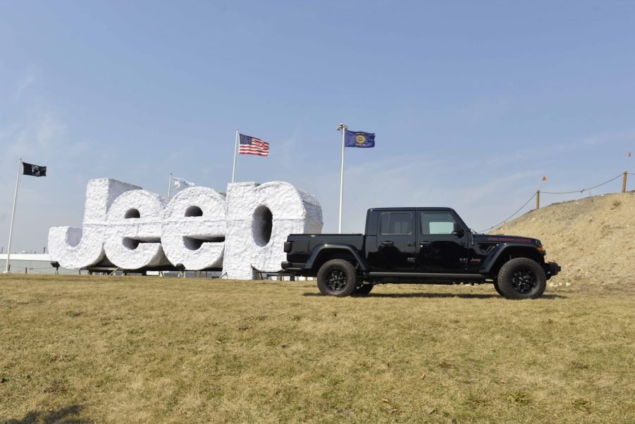 A Jeep Gladiator on display outside next to a Jeep sign