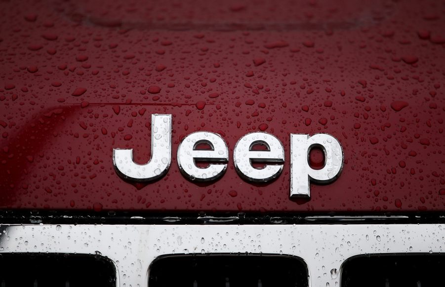 Jeep logo on red vehicle with rain drops over it